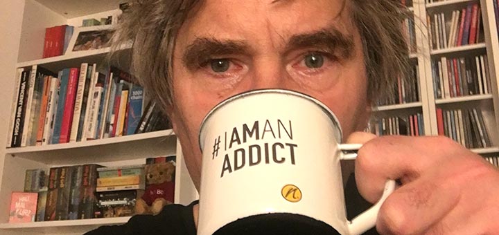 Jens trinkt aus Tasse mit Aufdruck #IAMANADDICT und nimble logo