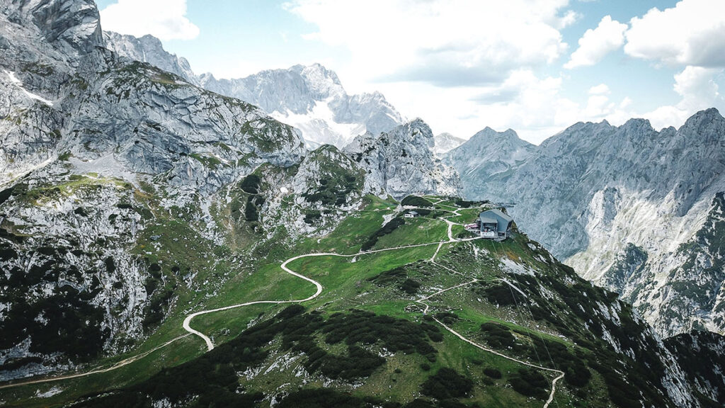 Bergstation Osterfelder Kopf (ca. 2050m) mit hohen Bergen im Hintergrund und Teil der Laufstrecke (Auf- und Abstieg) - Drohnenperspektive